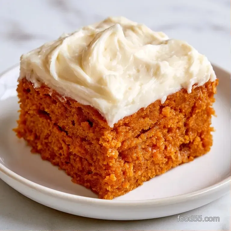 Three orange squares stacked on a white ceramic plate, garnished with a cinnamon stick and a dusting of spice.
